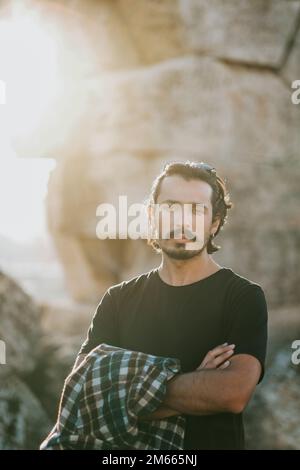 Junger, gutaussehender Mann, der vor alten Ruinen posiert Stockfoto