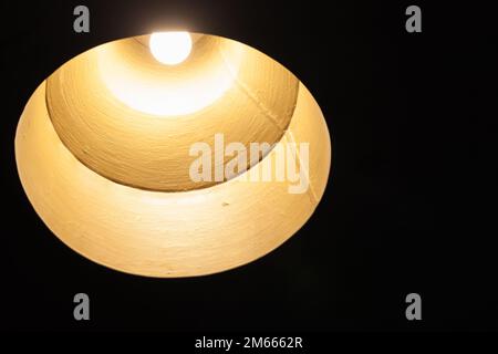 Kronleuchter im Vintage-Stil mit Wolframlampe in einer glänzenden runden Lampenschirm aus Metall, Nahaufnahme mit selektivem Fokus Stockfoto