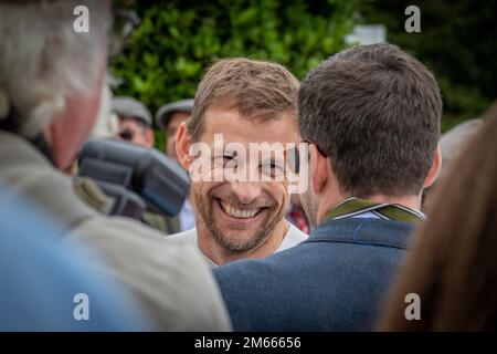 F1-Weltmeister Jenson Button lächelt bei Goodwood Revival Stockfoto