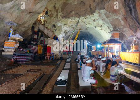 Die Menschen beten im Goa Giri Putri Tempel. Stockfoto