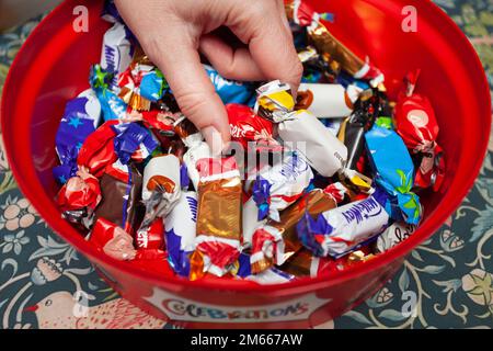 Hand für Schokolade aus der Celebrations-Schokoladenschachtel Stockfoto