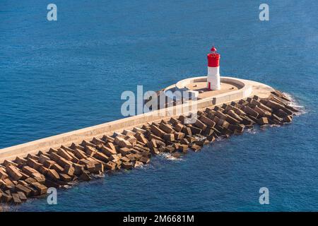 Rot-weißer Leuchtturm am Ende eines Wellenbrechers Stockfoto