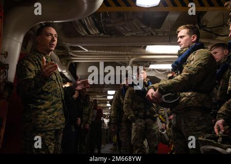 USA Oberstleutnant Harold Everhart, Befehlshaber des Combat Logistics Battalion, begrüßt die britischen Royal Marines mit 42 Kommandos an Bord des Amphibienschiffs USS Arlington (LPD 24) der San Antonio-Klasse, 6. April 2022. Arlington und 22. Marine Expeditionary Unit sind auf einem geplanten Einsatz unter dem Kommando und der Kontrolle der Task Force 61/2 in den USA Sechstes Flottengebiet zur Unterstützung von Übung Northern Viking 2022. Stockfoto