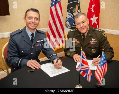 USA Armeegeneral James Dickinson, USA Befehlshaber des Weltraumkommandos (rechts) und Luftwaffenmarschall Paul Godfrey, Befehlshaber des britischen Weltraumkommandos (links), unterzeichnen eine Vereinbarung zwischen den Vereinigten Staaten und dem Vereinigten Königreich in Colorado Springs, Colorado, Colorado. 6. April 2022. In der Vereinbarung wird die Absicht dargelegt, Informationen über die Lage im öffentlichen Raum zwischen den USA und Großbritannien auszutauschen Diese Vereinbarungen fördern Offenheit, Vorhersehbarkeit des Raumfahrtbetriebs und Transparenz für das Bewusstsein für den Weltraumbereich. Stockfoto