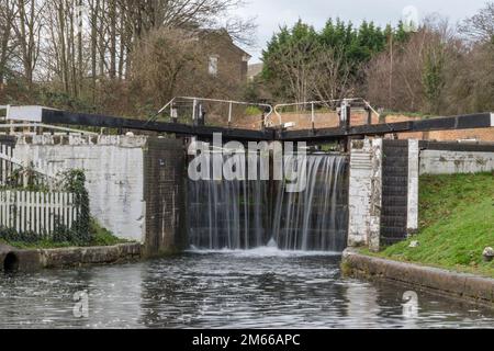 Wasser fließt über die Schleusentore des Hanwell Flight (Nr. 95) auf dem Grand Union Canal in Hanwell, London, Großbritannien. Stockfoto