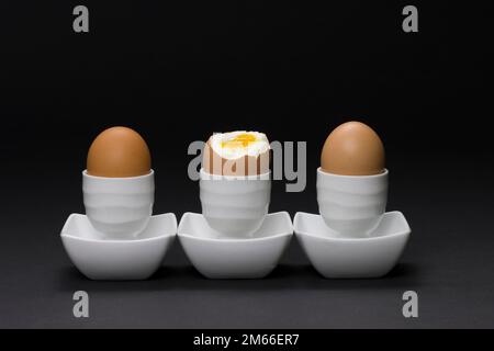 3 gekochte Eier in Eierbechern Stockfoto