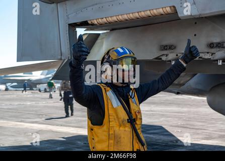 220407-N-ZE328-1119 IONISCHES MEER (7. April 2022) Aviation Boatswain's Mate (Handling) Airman Nadia Chapel aus Cincinnati, Ohio, leitet den Piloten einer F/A-18 auf dem Cockpit des Flugzeugträgers der Nimitz-Klasse USS Harry S. Truman (CVN 75) vom 7. April 2022. Die Harry S. Truman Carrier Strike Group befindet sich in einem geplanten Einsatz in den USA Sechster Flottenbereich zur Unterstützung der Interessen der USA, Verbündeten und Partner in Europa und Afrika. Stockfoto