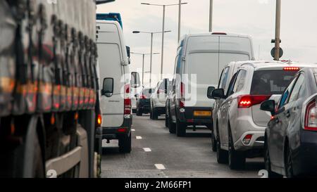 Schwerer, langsam fahrender Verkehr in einem Stau zu Stoßzeiten auf einer befahrenen Hauptstraße Stockfoto