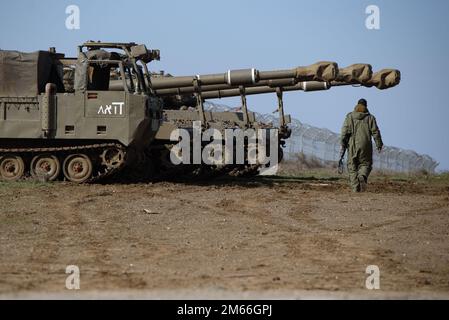 (230102) -- GOLAN HEIGHTS, 2. Januar 2023 (Xinhua) -- ein israelischer Soldat läuft am 2. Januar 2023 an M109 155mm selbstfahrenden Haubitzen in den israelisch besetzten Golanhöhen in der Nähe der syrischen Grenze vorbei. Israel startete am Montag einen Raketenangriff auf den internationalen Flughafen Damaskus, bei dem zwei Soldaten getötet wurden. (Ayal Margolin/JINI über Xinhua) Stockfoto