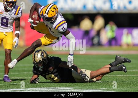 Orlando, Florida, USA. 2. Januar 2023: LSU Tigers Wide Receiver BRIAN THOMAS JR. (11) springt beim NCAA Cheez-IT Citrus Bowl-Spiel 2023 zwischen den LSU Fighting Tigers und den Purdue Boilermakers im Camping World Stadium in Orlando, Florida, am 2. Januar 2023 über einen Verteidiger. (Kreditbild: © Cory Knowlton/ZUMA Press Wire) Kredit: ZUMA Press, Inc./Alamy Live News Stockfoto