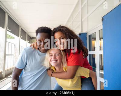 Drei verschiedene Teenager-Freunde, die Spaß in der Highschool haben Stockfoto