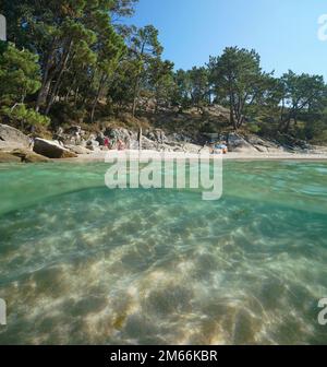Spanien, Galicien, Strand im Sommer an der Atlantikküste, Split Level Blick über und unter der Wasseroberfläche, Rias Baixas, Aldan, Cangas de Morrazo Stockfoto