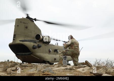 Soldaten der 4-6. Luftkavallerie-Staffel, 16. Kampfluftfahrt-Brigade, Joint Base Lewis-McChord, WA, derzeit in der Republik Korea stationiert, der 2. Kampfluftfahrt-Brigade zugewiesen, Gastgeber einer Spur Ride, am 7.-8. April 2022, Camp Humphreys, Republik Korea. Oberstleutnant Eric Megerdoomian wartet, während die Soldaten vom CH-47 Chinook abgesetzt werden, um den Rig marsch zu beginnen. Stockfoto