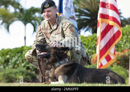 USA Air Force Staff Sergeant Tyler Parrish, 647. Sicherheitsgeschwader, arbeitender Hundeführer, Haustiere MWD Chewy, bei einer Ruhestandszeremonie am 8. April 2022, auf der Joint Base Pearl Harbor-Hickam, Hawaii. Chewy diente acht Jahre lang bei JBPHH als Drogenspürhund. Stockfoto