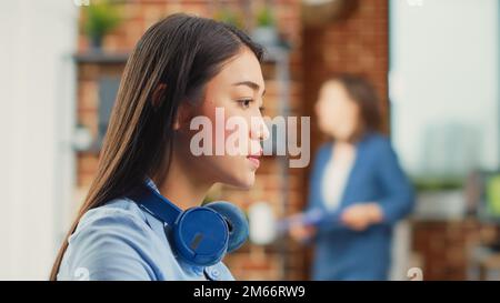 Junger Grafiker, der Bearbeitungssoftware am Computer verwendet, arbeitet an professionellem Multimedia-Design in einem Agenturstudio. Weibliche Redakteurin entwickelt neue Farbgradbilder mit Interface. Schließen. Stockfoto