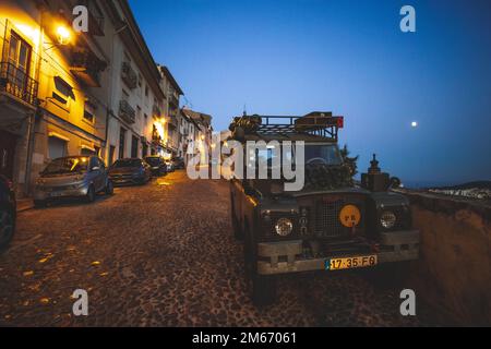 Der Mond geht nachts in Coimbra auf und beleuchtet einen 1970er Land Rover 2A/3, Portugal. Stockfoto