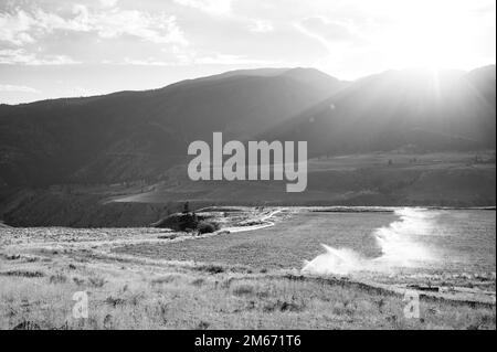 Eine schwarz-weiße Landschaft der Region British Columbia Caribou an einem sonnigen Tag mit bewässerten Heufeldern. In der Nähe von Lillooet BC, Kanada. Stockfoto