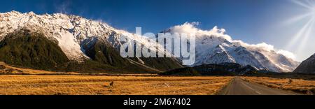 Der lange, gerade Highway führt durch das Tal im Alpental in Richtung des höchsten Berges Neuseelands Stockfoto