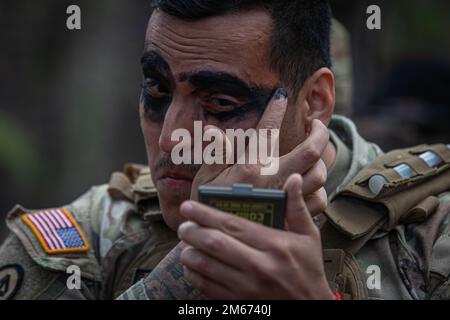 EIN US-AMERIKANISCHER Army Soldier trägt tarnierte Gesichtsfarbe während des 1.-254. Infantry Advanced Leaders Course 22-02 des Regional Training Institute auf Joint Base McGuire-Dix-Lakehurst, New Jersey, 9. April 2022. Der Infanterie Advanced Leaders Kurs ist ein branchenspezifischer Kurs, der Soldaten, die für eine Beförderung zum Staff Sgt. Ausgewählt wurden, eine Gelegenheit bietet, Führungsqualitäten, technische Fähigkeiten, taktisches Fachwissen und Erfahrung zu verbessern, die zur Leitung von Einheiten in Mannschaftsgröße erforderlich sind. Stockfoto