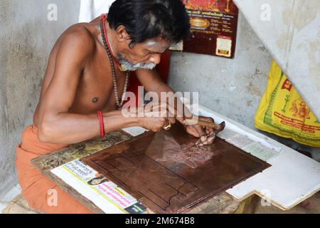 Ein Handwerker, der in seiner Werkstatt auf dem Gelände des Meenakshi Amman Tempels in Madurai, Tamil Nadu, Indien arbeitet. Stockfoto