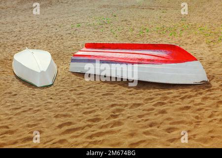 Holzschuppen im Sandstrand. Fischerboote an der Küste Stockfoto