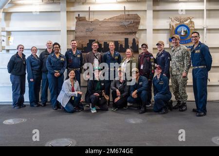 220409-N-VQ947-1190 PAZIFIK (9. April 2022) – Matrosen an Bord der Amphibien-Anlegestelle USS Portland (LPD 27) posieren während eines Besuchs des Programms „Leaders to Sea“ am 9. April 2022 für ein Foto mit Ehrengästen. Portland führt gerade Routineeinsätze in der US-3.-Flotte durch. Stockfoto