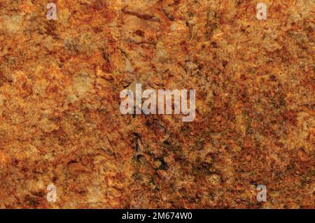 Roher Pegmatiter Feldspat igmatisches Gesteinserrakotta-Muster, rostiges Orange Rot goldgelber horizontaler Hintergrund, grobe, helle Kristalle-Textur Stockfoto