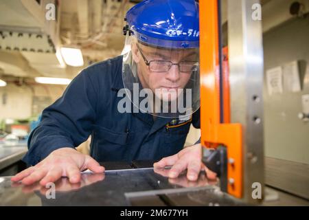 Aviation Structural Mechanic Airman Apprentice Hunter Scardami aus Aurora, Colorado, der Abteilung für die Zwischenwartung von Flugzeugen der USS Gerald R. Ford (CVN 78) zugewiesen ist, stellt am 10. April 2022 einen Spotting-Dolly-Instrumentenbrett her. Ford ist im Atlantik im Einsatz und führt im Rahmen der maßgeschneiderten Grundphase des Schiffes vor dem Einsatz Beförderungsqualifikationen und die Integration von Streikgruppen durch. Stockfoto