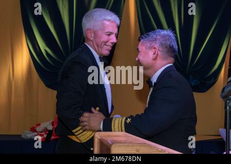 YOKOSUKA, Japan (10. April 2022) Rear ADM. Butch Dollaga, Commander, Submarine Group 7, übergibt das Mikrofon an Vice ADM. Karl Thomas, Commander, U.S. 7. Fleet, während des 122. Submarine Birthday Ball bei Fleet Activities Yokosuka 10. April 2022. Der Ball wurde von der Submarine-Gruppe 7 koordiniert, die vorwärtsstationierte Kampftruppen über das gesamte Spektrum der Unterwasserkriegsführung im westlichen Pazifik, im Indischen Ozean und im Arabischen Meer leitet. Stockfoto