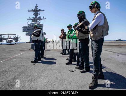 220411-N-OL632-1227 ATLANTISCHER OZEAN (11. April 2022) Seeleute, die dem Flugzeugträger USS George H.W. zugeteilt wurden Bush (CVN 77), bereit, Flugzeuge zu Bergen und auf dem Cockpit freizulassen, 11. April 2022. George H.W. Bush bietet der nationalen Kommandobehörde flexible, anpassbare Kampfkapazitäten als Flaggschiff der Trägerstreikgruppe, die die maritime Stabilität und Sicherheit aufrechterhält, um den Zugang zu gewährleisten, Aggressionen abzuwehren und die Interessen der USA, Verbündeten und Partner zu verteidigen. Stockfoto