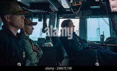 PAZIFIK (11. April 2022) Captain Kelly Fletcher, Befehlshaber des Amphibienschiffs USS Essex (LHD 2), stammt aus West Hempstead, New York, rechts, Kapitän Wayne Liebold, Exekutivbeamter von Essex, stammt aus Leesburg, Georgia, Left, Und Kapitän Aaron Taylor, ein Einheimischer aus Carlsbad, Kalifornien, der Essex zugeteilt wurde, überwacht den Transit des Schiffs auf der Brücke am 11. April 2022. Essex führt gerade Routineeinsätze in der US-3.-Flotte durch. Stockfoto