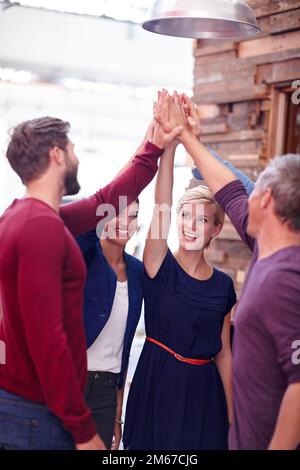 Ich Gewinne den ganzen Weg. Eine Gruppe von Kreativprofis, die sich gegenseitig High-Five-Gespräche machen, um einen Erfolg zu feiern. Stockfoto