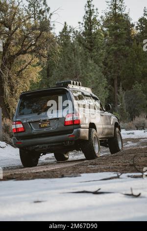 Hinterwinkel des Toyota Land Cruiser Overland Off-Road SUV auf dem schneebedeckten Bergweg Stockfoto