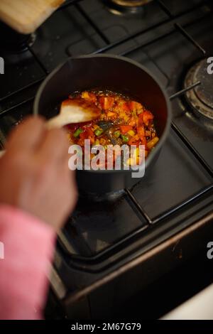 Köstliches Essen. Ein Mann, der eine Mischung aus gehacktem Gemüse auf dem Herd kocht. Stockfoto