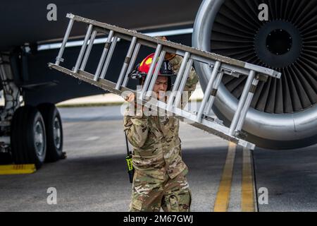 USA Air Force Staff Sgt. Joseph Cristi, 18. Civil Engineer Squadron Fire Defighter, trägt eine Leiter weg von einem 909. Air Tanken Squadron KC-135 Stratotanker Flügel während des Trainings auf dem Luftwaffenstützpunkt Kadena, Japan, 12. April 2022. 18. die Feuerwehrleute der CES suchten bei einem simulierten Cockpit- oder Triebwerksbrand nach "nicht verbuchten Personen", um ihre Rettungs- und Wiederherstellungsfähigkeiten zu testen. Stockfoto