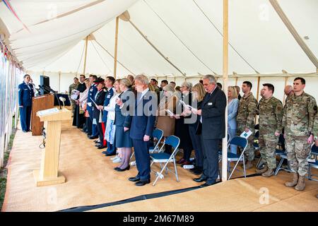 Ehrengäste und Fluggäste des 501. Combat Support Wing singen die Nationalhymne zum Abschluss der Queen's Green Canopy Veranstaltung auf der RAF Croughton, England, 13. April 2022. Die Veranstaltung feierte das Platinum Jubilee der Königin, das 70. Jahr ihrer Herrschaft. Während der Veranstaltung wurden Bäume gepflanzt, um ein Vermächtnis zu Ehren der Führung der Königin über die Nation zu schaffen. Stockfoto