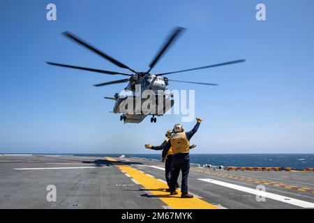 220413-N-NY430-2098 PAZIFIK (13. April 2022) – Aviation Boatswain’s Mate (Handling) 3. Klasse Jonathan Walker, rechts, Und Airman Kory Vogel leitet einen CH-53E Super-Hengst, der dem Marine Heavy Helicopter Squadron (HMH) 462 zugeteilt wurde, während er vom Cockpit des Amphibien-Kampfschiffs USS Makin Island (LHD 8) startet, April 13. Aviation Boatswain leitet die Bewegung und Beobachtung von Flugzeugen an Land und über Wasser. Makin Island führt Routineeinsätze in der US-3.-Flotte durch. Stockfoto