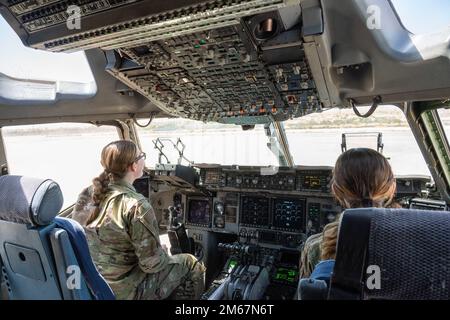 Flugzeuge mit dem 49. Equipment Maintenance Squadron sitzen im Cockpit eines C-17 Globemaster III vom 97. Air Mobility Wing während eines Pet the Jet Events am 13. April 2022 auf dem Luftwaffenstützpunkt Holloman, New Mexico. Die Veranstaltung gab Holloman Airmen die Gelegenheit, die Merkmale und Fähigkeiten des C-17 von den Piloten und der Flugbesatzung zu sehen und mehr darüber zu erfahren. Stockfoto