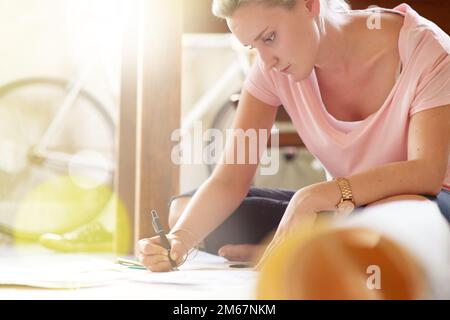 Kunst wäscht aus der Seele den Staub des Alltags. Eine weibliche Grafikerin, die zu Hause an Illustrationen arbeitet. Stockfoto