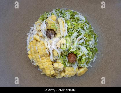 Draufsicht von eingetropftem, unreifem Reiflocken-Müsli (Glutinreis wird zu „Khao Mao Khlook“ verarbeitet) und gedämpftem Zuckermais gemischt mit geriebenem jungen Kokos Stockfoto