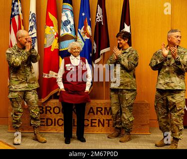 Das Brooke Army Medical Center Kommandiert General Brigg. General Clinton Murray, stellvertretender Befehlshaber der BAMC Oberstleutnant Kimberlie Biever und Kommandoleiter Major Thurman Reynolds applaudierten Shirley Adcock während der Ehrenamtlichen Anerkennungszeremonie bei BAMC, Fort Sam Houston, Texas, am 13. April 2022. Der 94-Jährige geht aus dem Freiwilligendienst in Rente, nachdem er fast 26 Jahre bei BAMC gearbeitet hat. Stockfoto