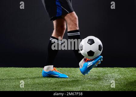 Das Spiel, das alle zusammenbringt. Ein Fußballspieler, der Fußball spielt. Stockfoto