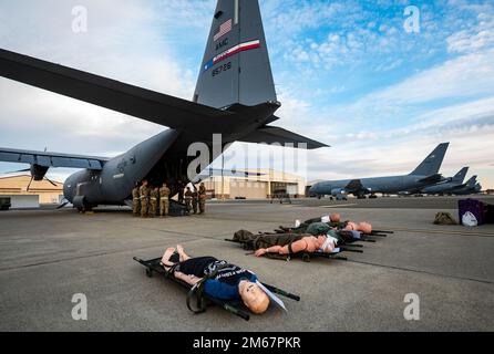 USA Flugzeuge der 60. Evakuierungsstaffel simulierten Patienten in der Nähe eines C-130J Super Hercules, der der 317. Luftwaffenstaffel Dyess Air Force Base, Texas, während eines Trainings am Travis AFB, Kalifornien, am 13. April 2022 zugeteilt wurde. Die Mission der AE ist es, Mitgliedern des Dienstes, Angehörigen, Veteranen und Verbündeten eine zuverlässige Versorgung in der Luft zu bieten. Diese Routineschulungen verbessern die Fähigkeit von Airmen, auf reale Situationen in einem Moment zu reagieren. Stockfoto