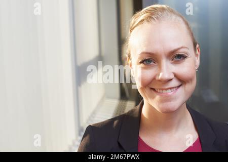 Erfolg bringt mir immer ein Lächeln ins Gesicht. Porträt einer attraktiven Geschäftsfrau, die im Büro steht. Stockfoto