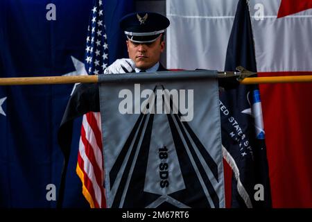 USA Der leitende Airman Mark Macias der Luftwaffe, Mitglied der Ehrenwache des Stützpunktes der Vandenberg-Weltraumstreitkräfte und dem 30. Geschwader für zivile Ingenieure zugeteilt, deckt die frühere Flagge des 18. Geschwaders der Weltraumverteidigung hinter der neuen Flagge der Einheit während einer Zeremonie zur Neubenennung auf dem Stützpunkt der Vandenberg-Weltraumstreitkräfte, Kalifornien, April 13, ab. 2022. Die 18 SDS, früher 18. Space Control Squadron, wird weiterhin US-amerikanisch sein Der führende Anbieter von kontinuierlichem, umfassendem und kämpfungsrelevantem Bewusstsein für den Weltraumbereich des Weltraumkommandos. Stockfoto