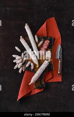 Vertikale Zusammensetzung mit fermentierten Salami-Würsten auf Holzschneidplatten Stockfoto