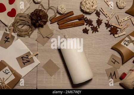 Eine nicht erkennbare junge Frau malt Zahlen auf Kerzen. Frau macht hausgemachte Adventskalender mit eigenen Händen gemacht Schritt für Schritt selbstgemachtes Kunsthandwerk Machen Sie es selbst. Vorbereitung auf das weihnachtskonzept. Saisonale Aktivitäten für Kinder, Familienurlaub im Winter. Umweltfreundlich Geschenke. Öffnen Sie das Paket jeden Tag Stockfoto