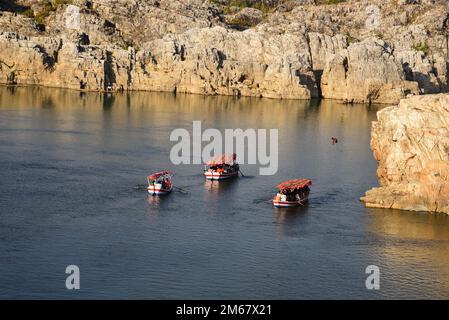 Besucher fahren am ersten Silvestertag rund um den Marble Rocks Wasserfall auf dem Narmada River in Bhedaghat, Jabalpur Stockfoto