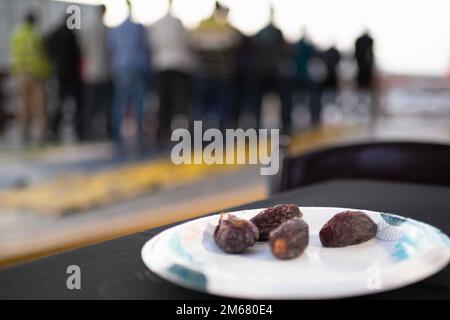 CAMP LEMONNIER, Dschibuti (14. April 2022) muslimische zivile Auftragnehmer beantworten den Aufruf zum Gebet bei einem iftar-Dinner im Camp Lemonnier, Dschibuti während des Ramadan, gesponsert von der Lagerkriminalität, der Vereinigung der leitenden Petty Officers und den Freiwilligen der Friends of Africa. Stockfoto