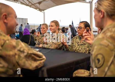 CAMP LEMONNIER, Dschibuti (14. April 2022) US-Militärangehörige, die nach Camp Lemonnier, Dschibuti, entsandt wurden, essen Datteln, um an der traditionellen Fastenpause teilzunehmen, während ein iftar-Dinner stattfindet, gesponsert von der Wardroom des Lagers, der Chief Petty Officers Association und den Friends of Africa Voulunteers. Stockfoto